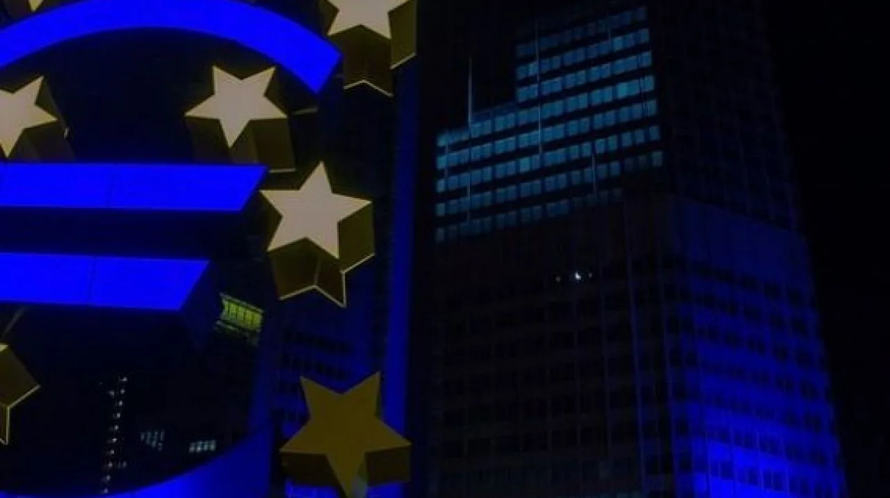 Simbolul euro iluminat noaptea, reflectând tensiuni economice globale.