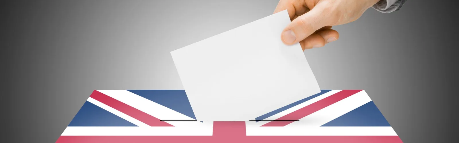 O mână introduce un buletin de vot într-o urnă cu steagul Marii Britanii.