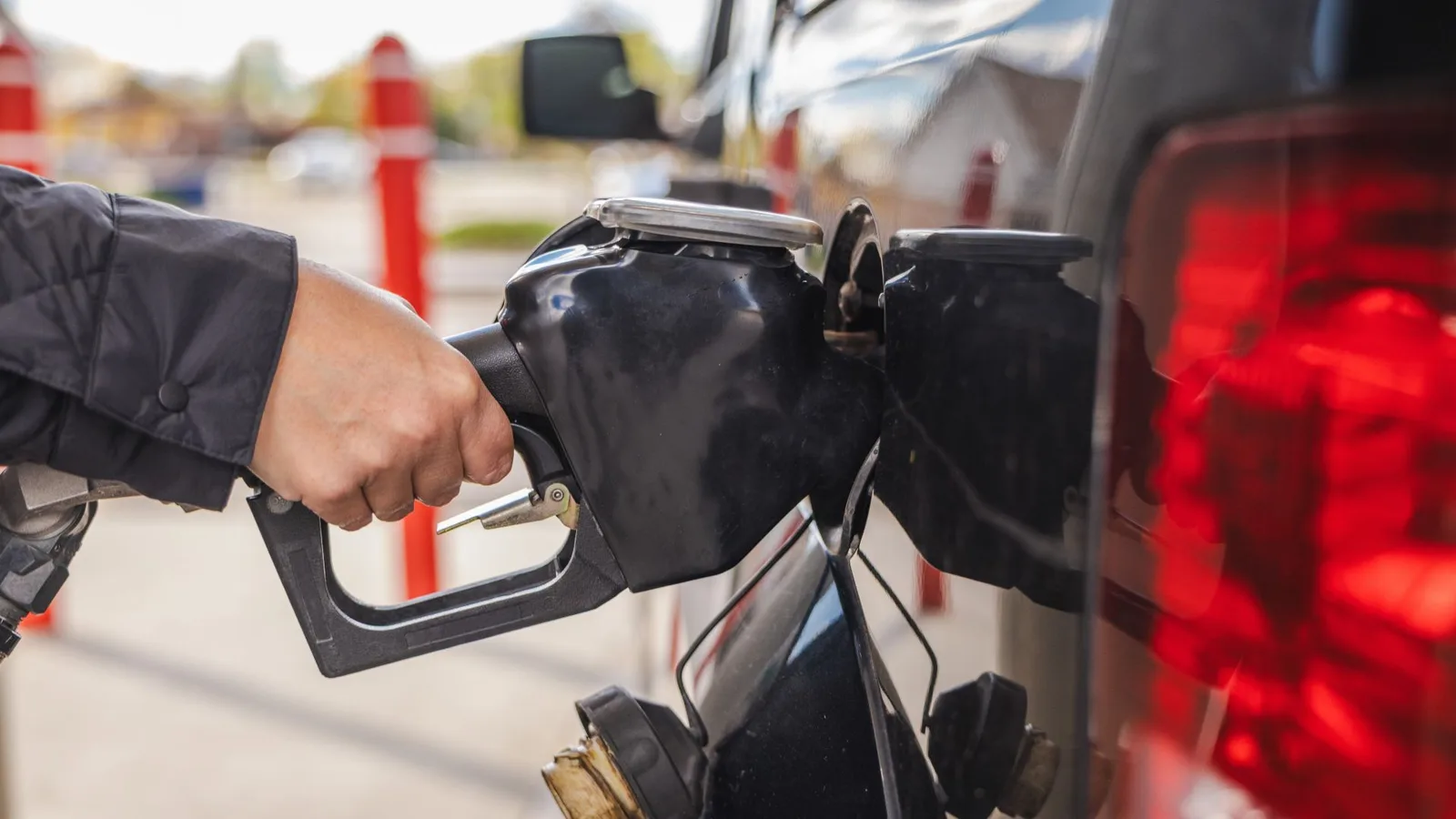 O mână umană umple un rezervor de carburant.