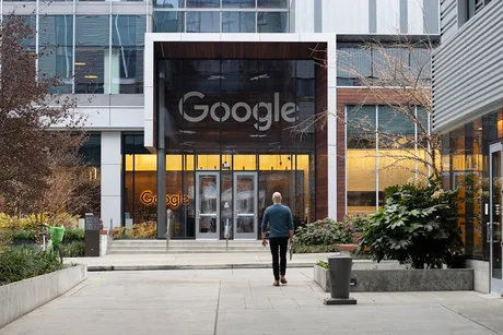 Intrarea principală a clădirii Google, cu un bărbat îndreptându-se spre ușă.