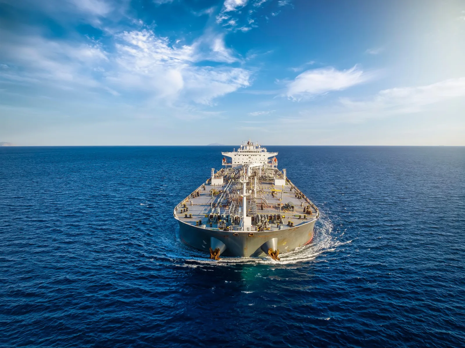 Nava de transport maritim navigând pe un ocean calm, sub un cer senin.