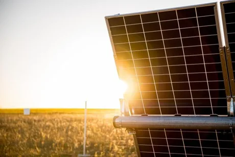 Panouri solare captând lumina soarelui într-un peisaj rural din România.