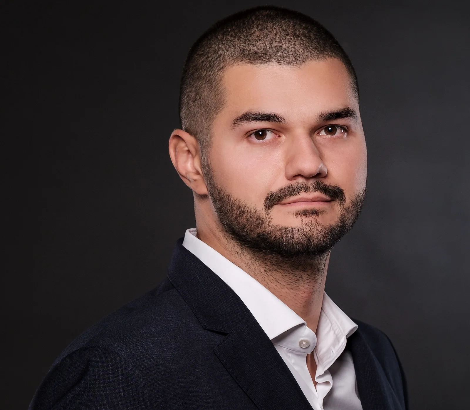 Portret al unui bărbat îmbrăcat elegant, cu o privire serioasă.