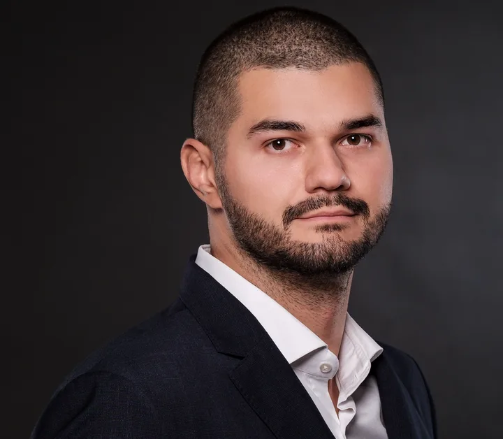 Portret al unui bărbat îmbrăcat elegant, cu o privire serioasă.