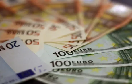 Bancnote euro aranjate pe o masă, simbolizând adoptarea monedei europene.