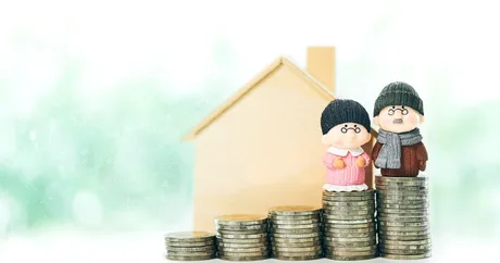 Pensionarii stau lângă monede, simbolizând economiile din fondurile de pensii.