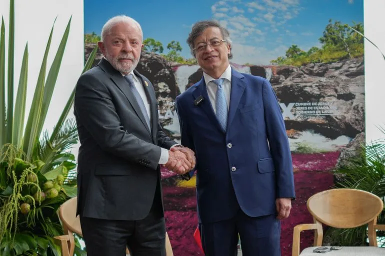 Lula și un oficial strâng mâinile la summitul CELAC din Columbia.