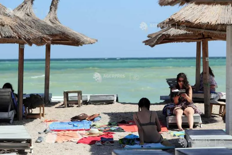 Plajă la Marea Neagră, cu turiști relaxându-se sub umbrele.