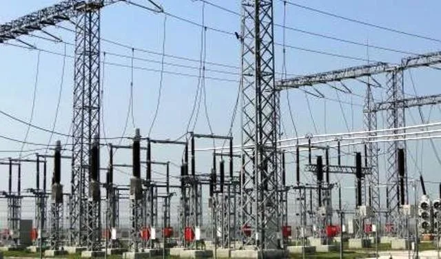 Rețea electrică cu stâlpi și cabluri în peisaj urban.