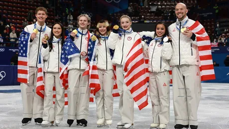 Echipa americană de patinaj artistic sărbătorește victoria cu medalii de aur.