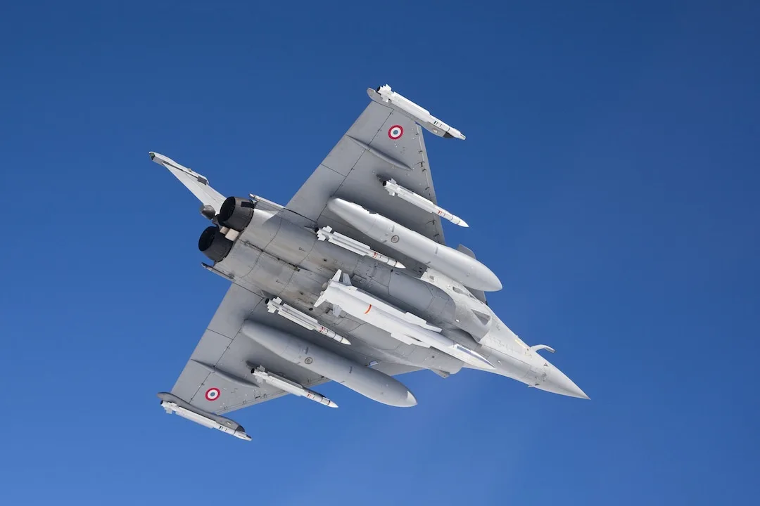 Avion de luptă Rafale zburând pe cer, cu aripile extinse.