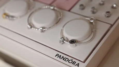 Bijuterii elegante expuse pe un suport, evidențiind designul Pandora.
