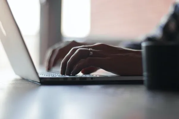 Mână folosind laptop pentru activități de e-business.
