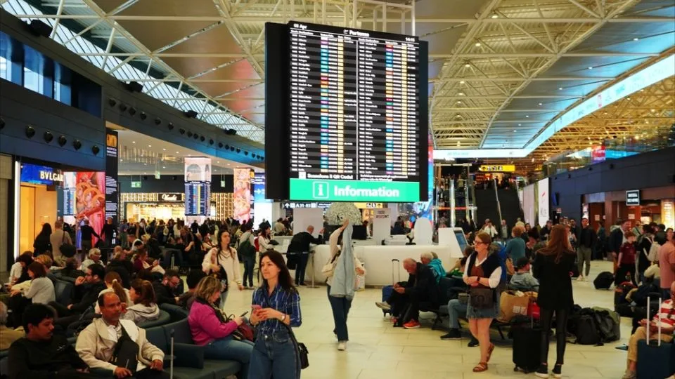 Aeroport aglomerat, pasageri așteptând zboruri internaționale.