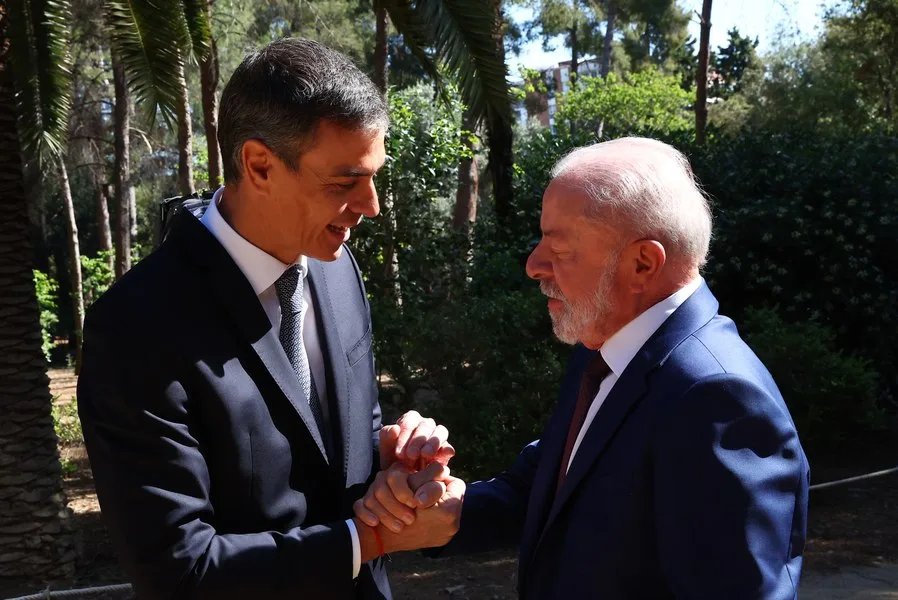 Pedro Sánchez și Luiz Inácio Lula da Silva discutând acorduri strategice în aer liber.