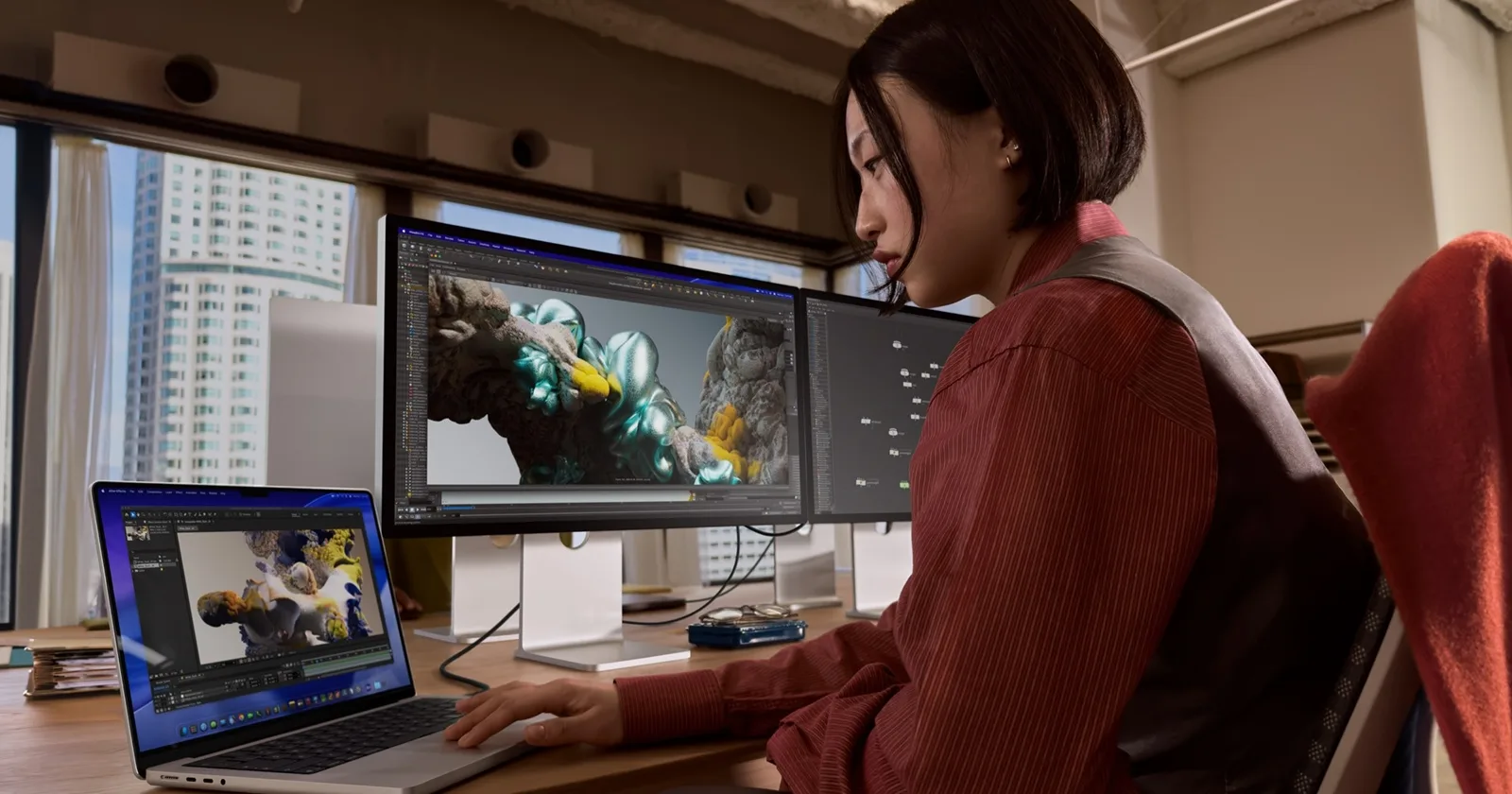 Utilizator lucrând la editare video pe monitoare Apple Studio Display 2026.