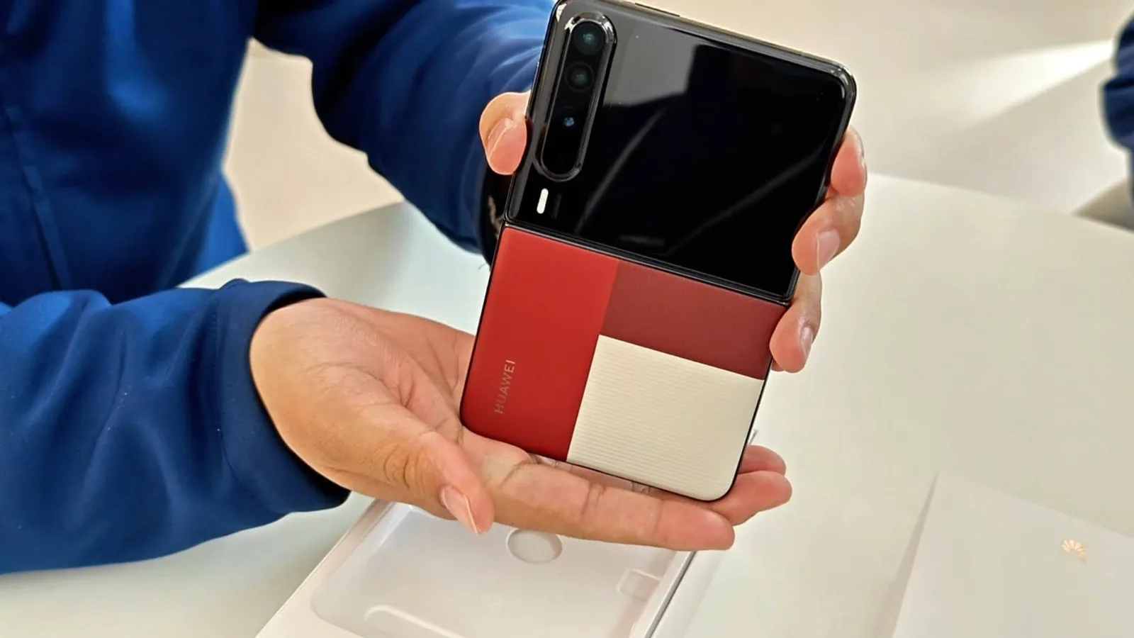 Un telefon pliabil în mână, cu un design modern și culori contrastante.