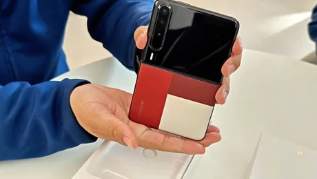 Un telefon pliabil în mână, cu un design modern și culori contrastante.