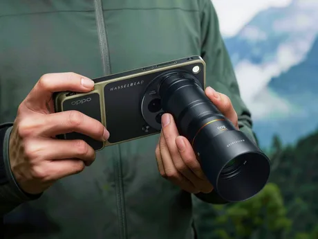 Utilizator care testează un smartphone cu lentilă zoom Hasselblad în natură.
