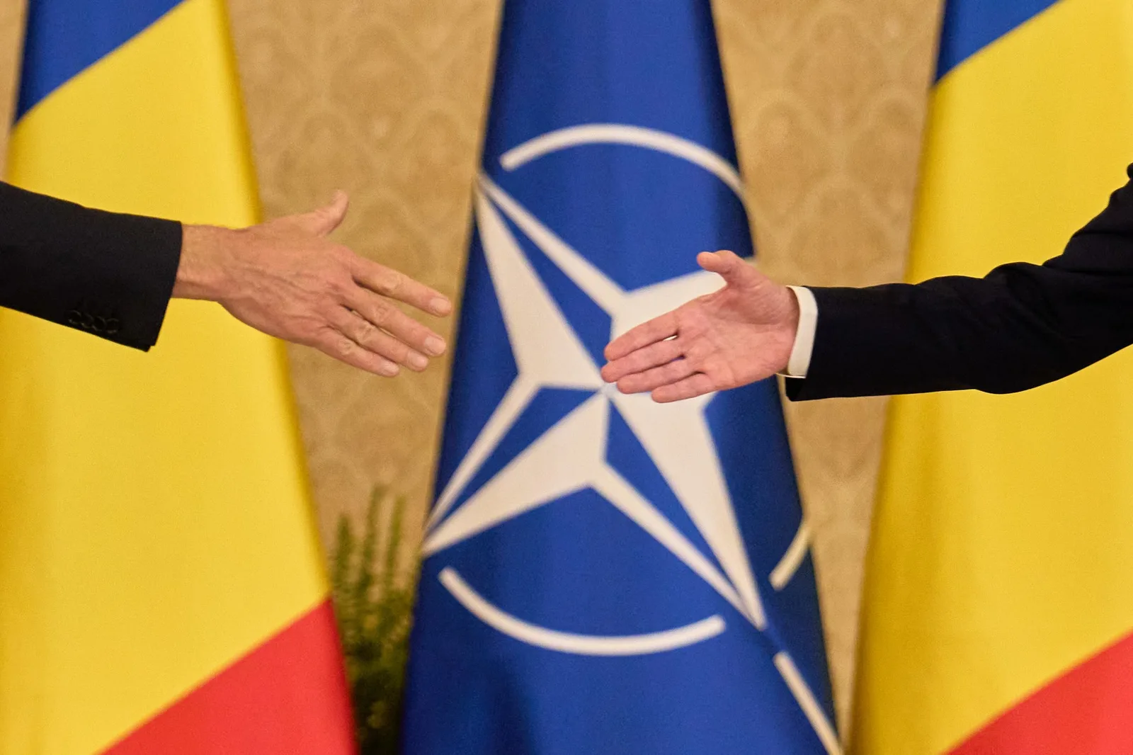 Mâini care se întâlnesc în semn de colaborare la summitul de securitate.