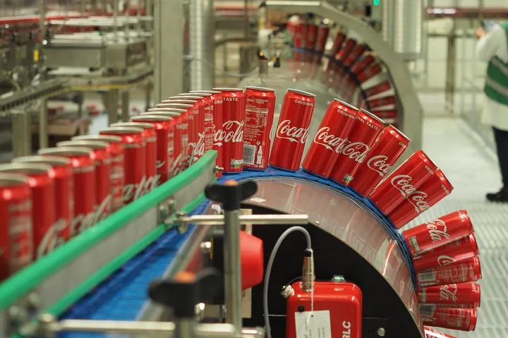 Linii de producție cu doze de Coca-Cola pe bandă rulantă.