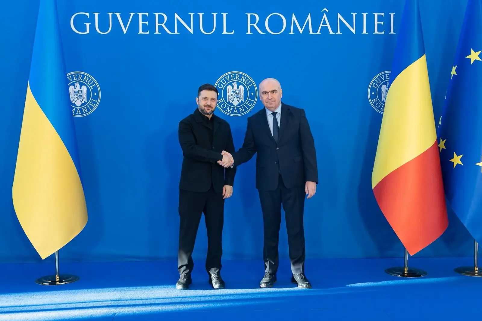 Zelenski și Bolojan strâng mâinile la Palatul Victoria, simbolizând cooperarea româno-ucraineană.
