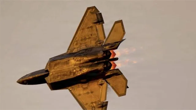 Un avion de vânătoare F-22 Raptor în zbor, cu motoarele aprinse.