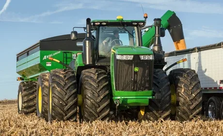 Tractor modern în câmp, utilizat pentru recolta de cereale.