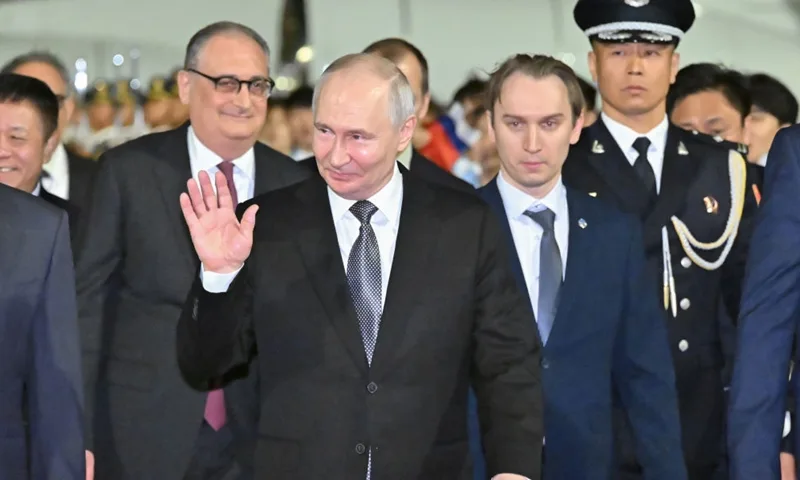 Vladimir Putin salută la sosirea în China pentru discuții economice.