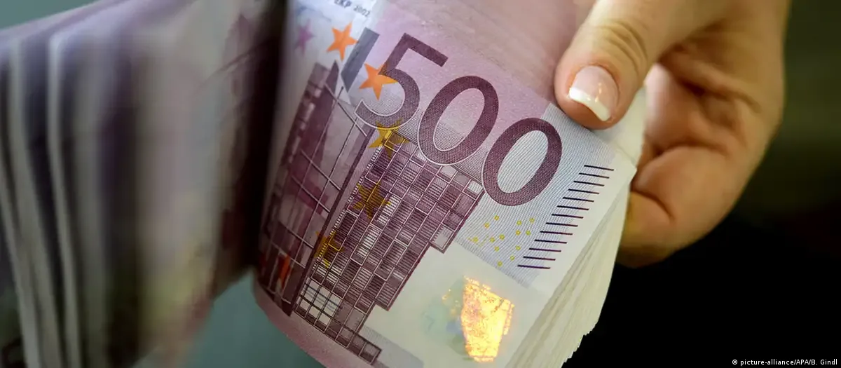 Bancnote de 500 de euro, aranjate cu grijă, în mâna unei persoane.