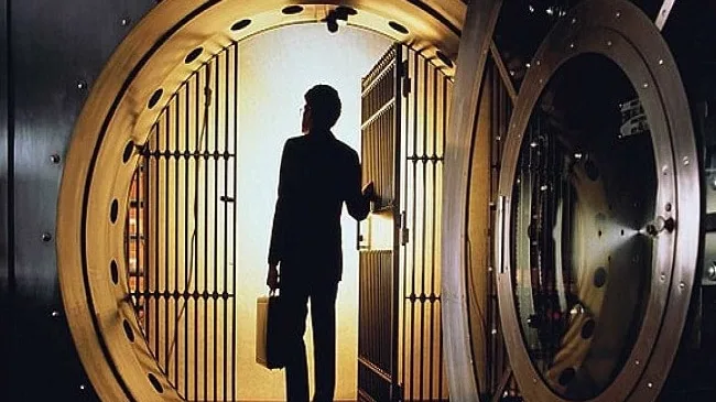 Persoană într-o bancă, reflectând asupra reglementărilor financiare stricte.