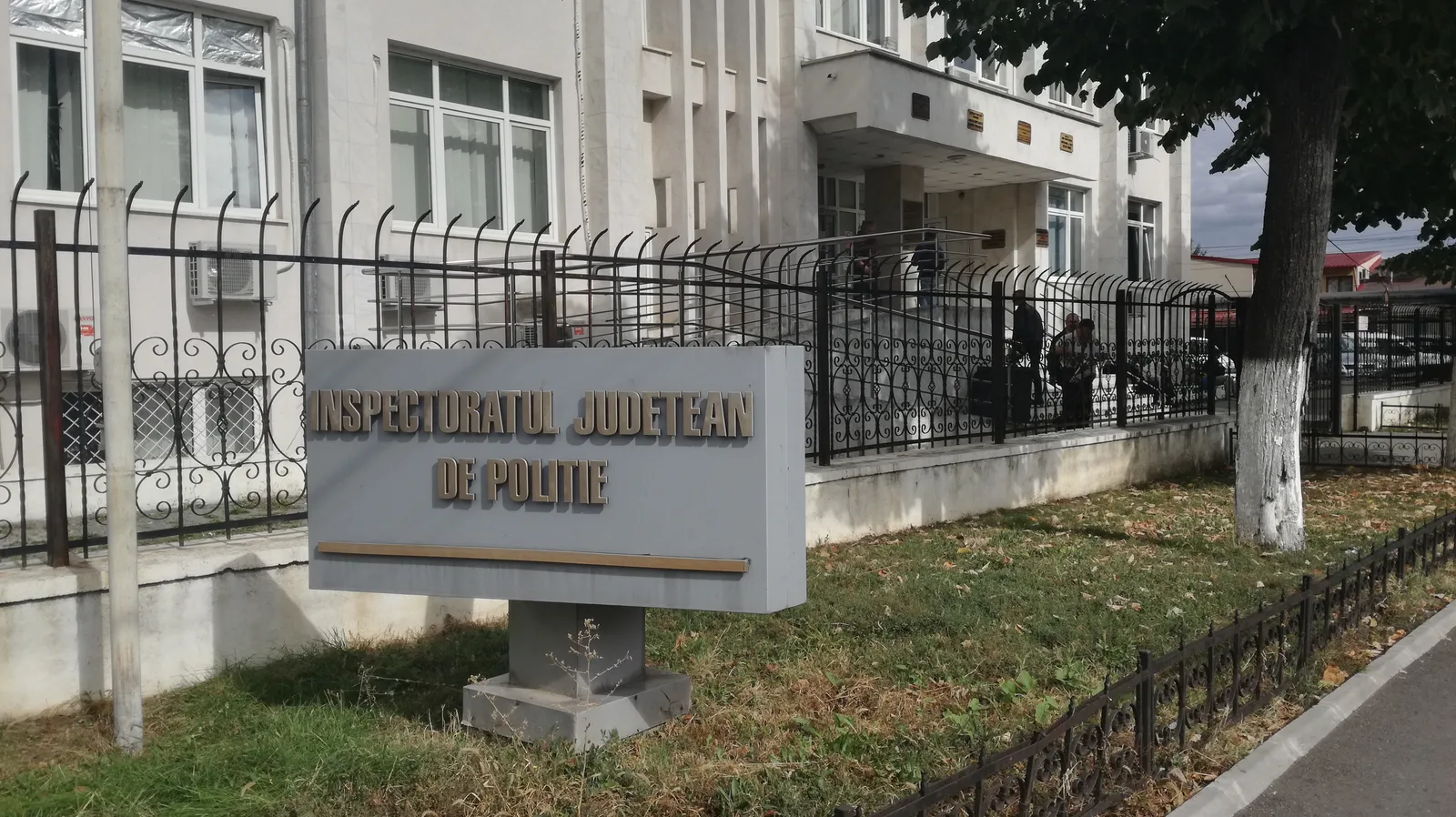 Clădirea Inspectoratului Județean de Poliție din Timișoara, cu oameni în față.
