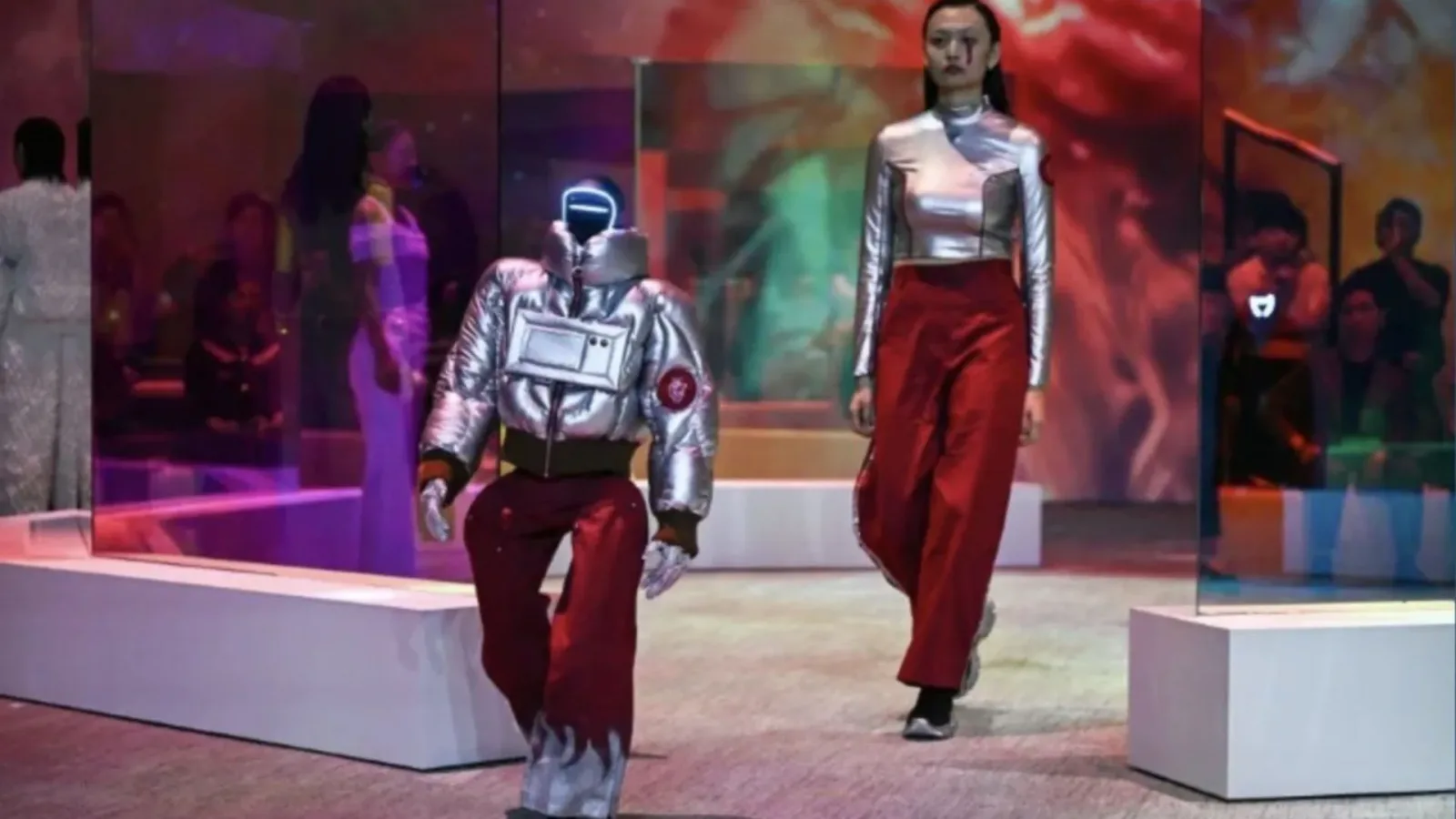 Roboți umanoizi și modele pe podium la un show de modă inovator din Seul.