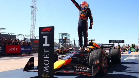 Pilot de Formula 1 sărbătorind victoria pe circuitul de curse.